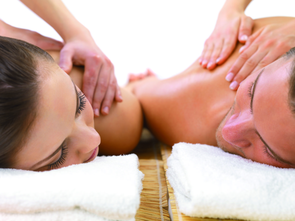 Close up of man and woman getting massage together, on romantic holiday at the spa.